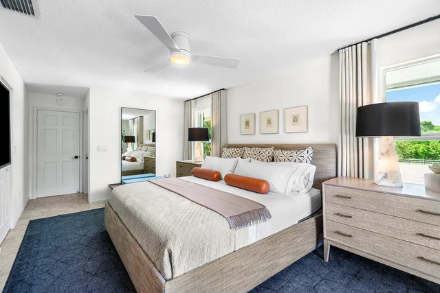 a bedroom with a bed and a large window