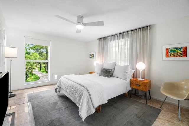 a view of a swimming pool with lounge chairs in patio with a lake view