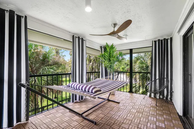 a view of a white house with a big yard and potted plants
