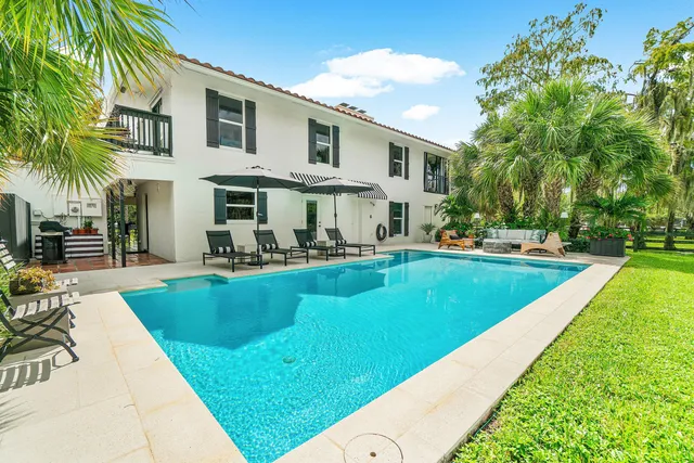a view of a large residential houses with yard and lake view