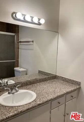 a bathroom with a granite countertop sink and a mirror