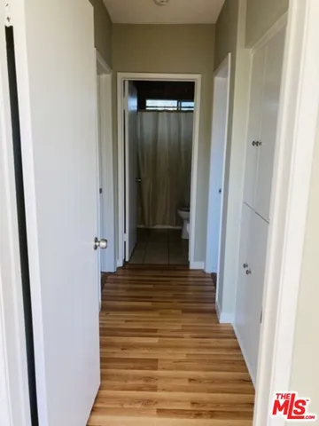 a view of a hallway with wooden floor and closet