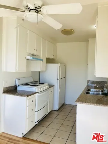 a kitchen with a stove a sink and a refrigerator
