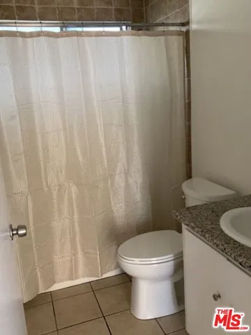 a white toilet sitting next to a shower curtain