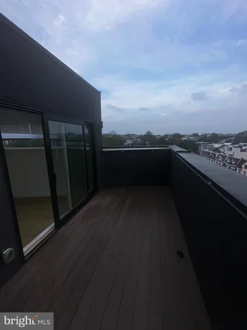 a view of roof deck with wooden floor and fence