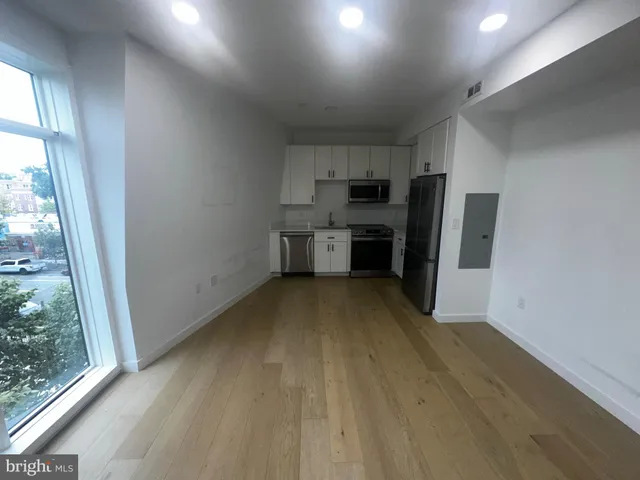 a view of a kitchen with a sink refrigerator and window