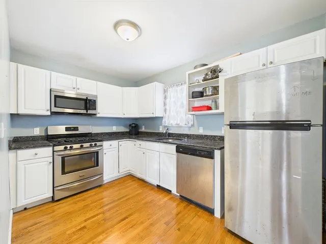 a kitchen with granite countertop a refrigerator and a sink