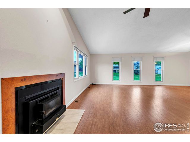 a view of an empty room with window and fire place