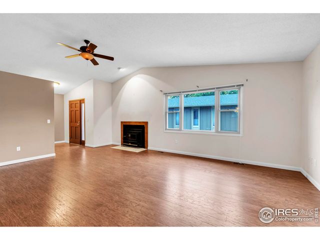 a view of an empty room with window and fireplace