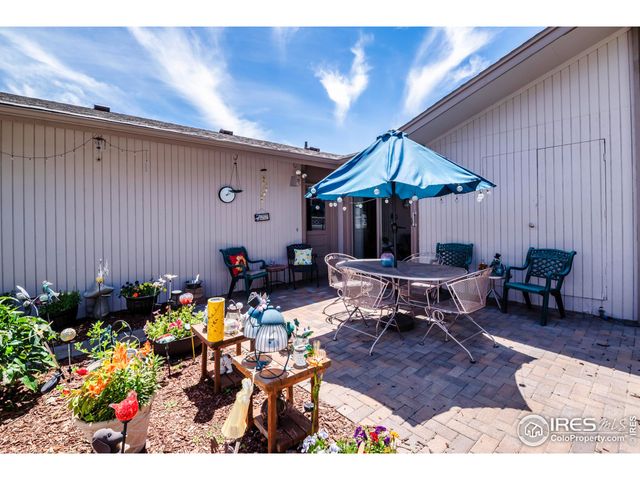 a backyard of a house with dining table and chairs