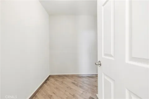 a spacious bedroom with a bed a mirror on dresser and a window