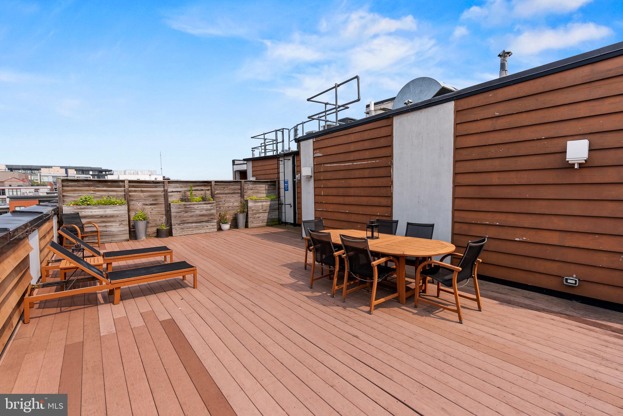 2101 11th Street Northwest, Unit 302 Washington, DC 20001 - Photo 19 of 26 a view of a roof deck with table and chairs a barbeque with wooden floor and fence