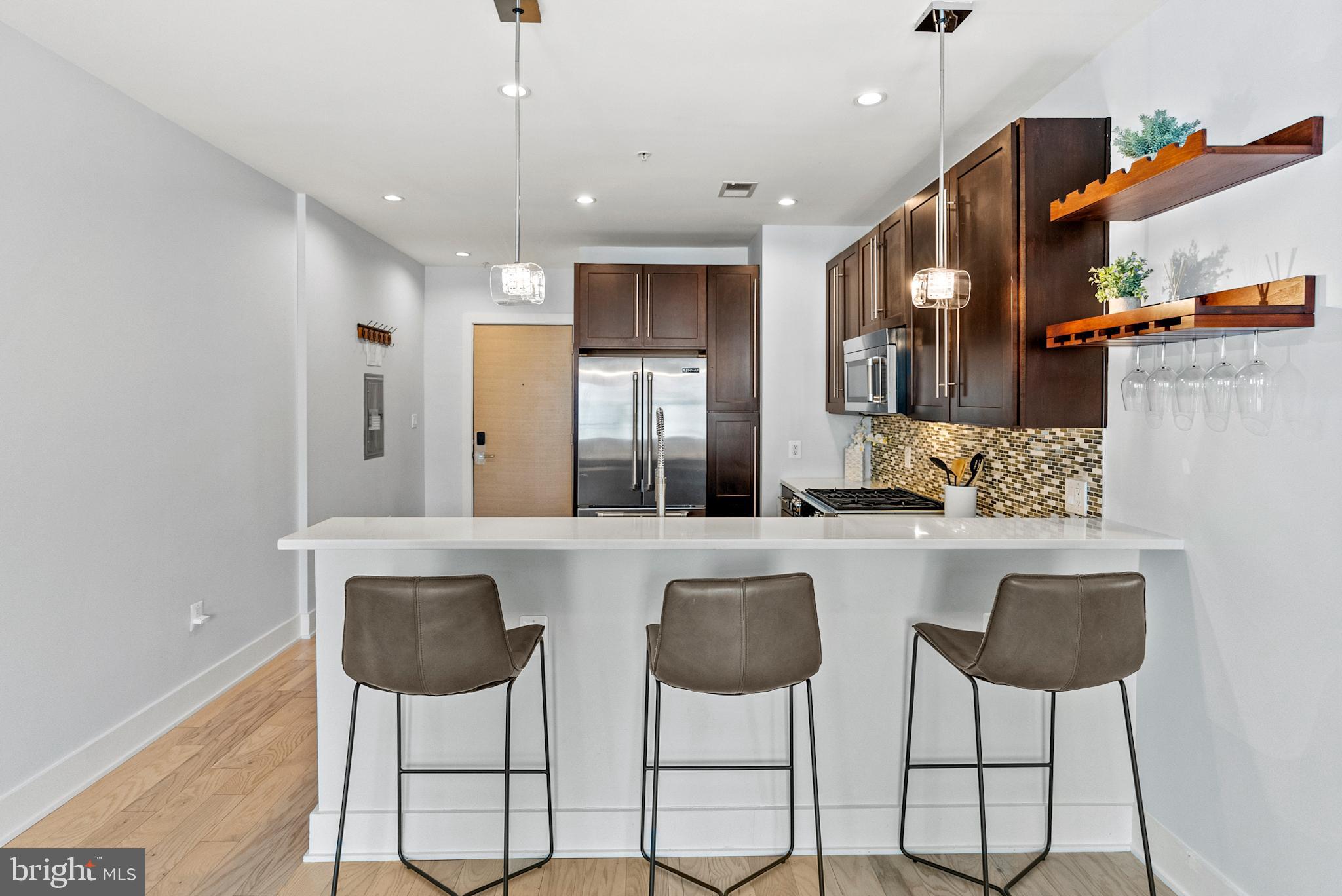 2101 11th Street Northwest, Unit 302 Washington, DC 20001 - Photo 5 of 26 a kitchen with stainless steel appliances kitchen island granite countertop a dining table and chairs