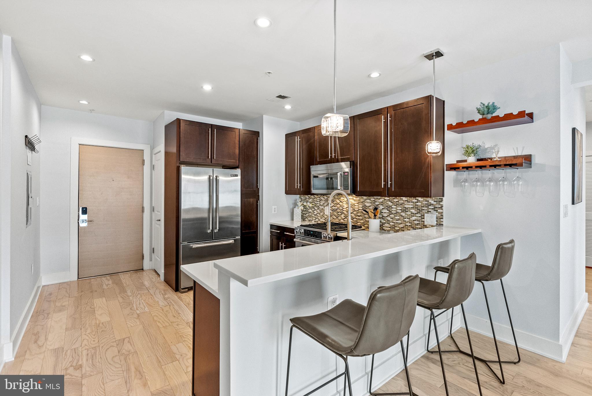 2101 11th Street Northwest, Unit 302 Washington, DC 20001 - Photo 6 of 26 a kitchen with stainless steel appliances kitchen island granite countertop a refrigerator and a stove top oven