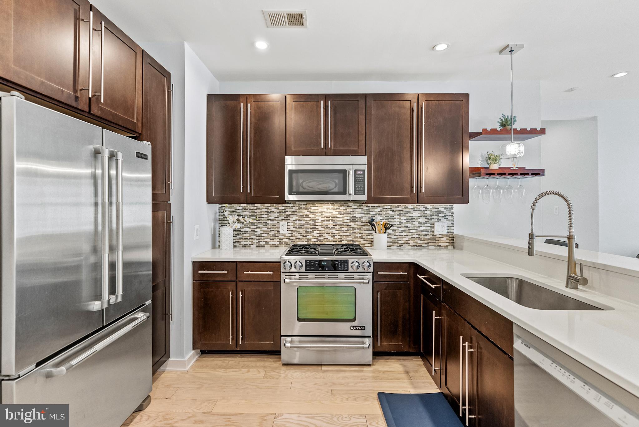 2101 11th Street Northwest, Unit 302 Washington, DC 20001 - Photo 7 of 26 a kitchen with stainless steel appliances wooden cabinets and sink