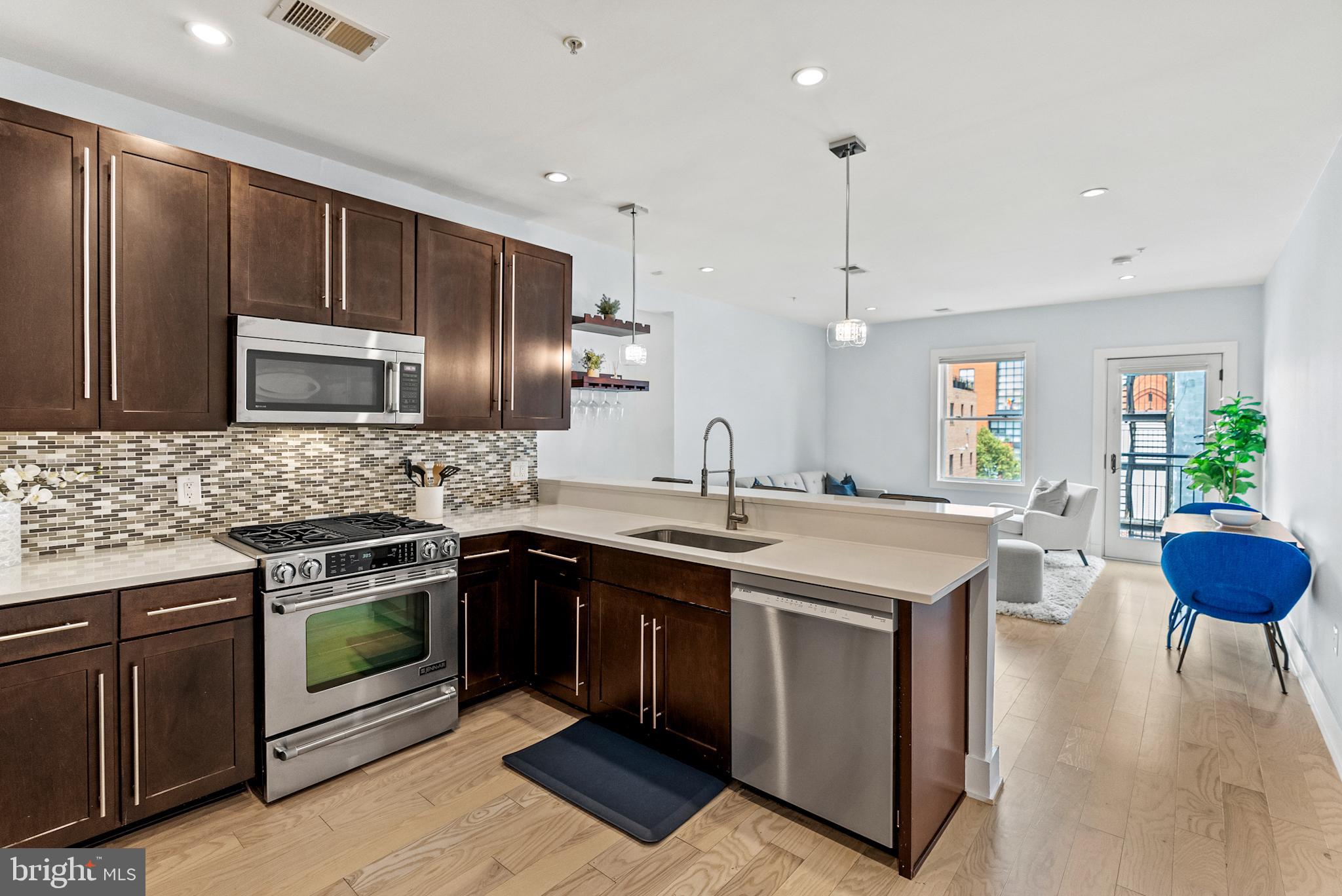 2101 11th Street Northwest, Unit 302 Washington, DC 20001 - Photo 8 of 26 a kitchen with stainless steel appliances granite countertop a sink stove and refrigerator