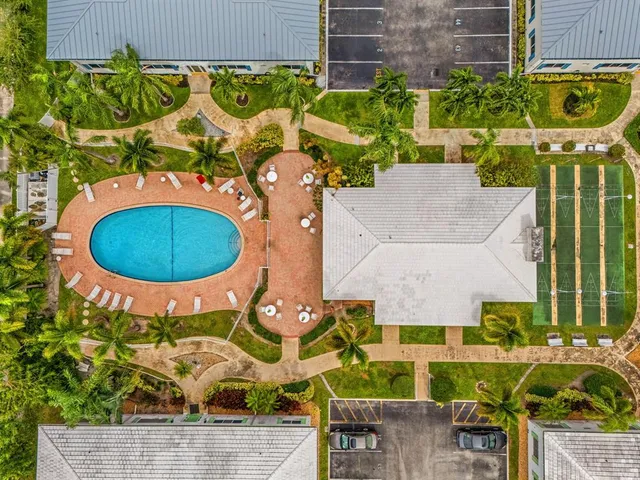 an aerial view of a house with a swimming pool and chairs