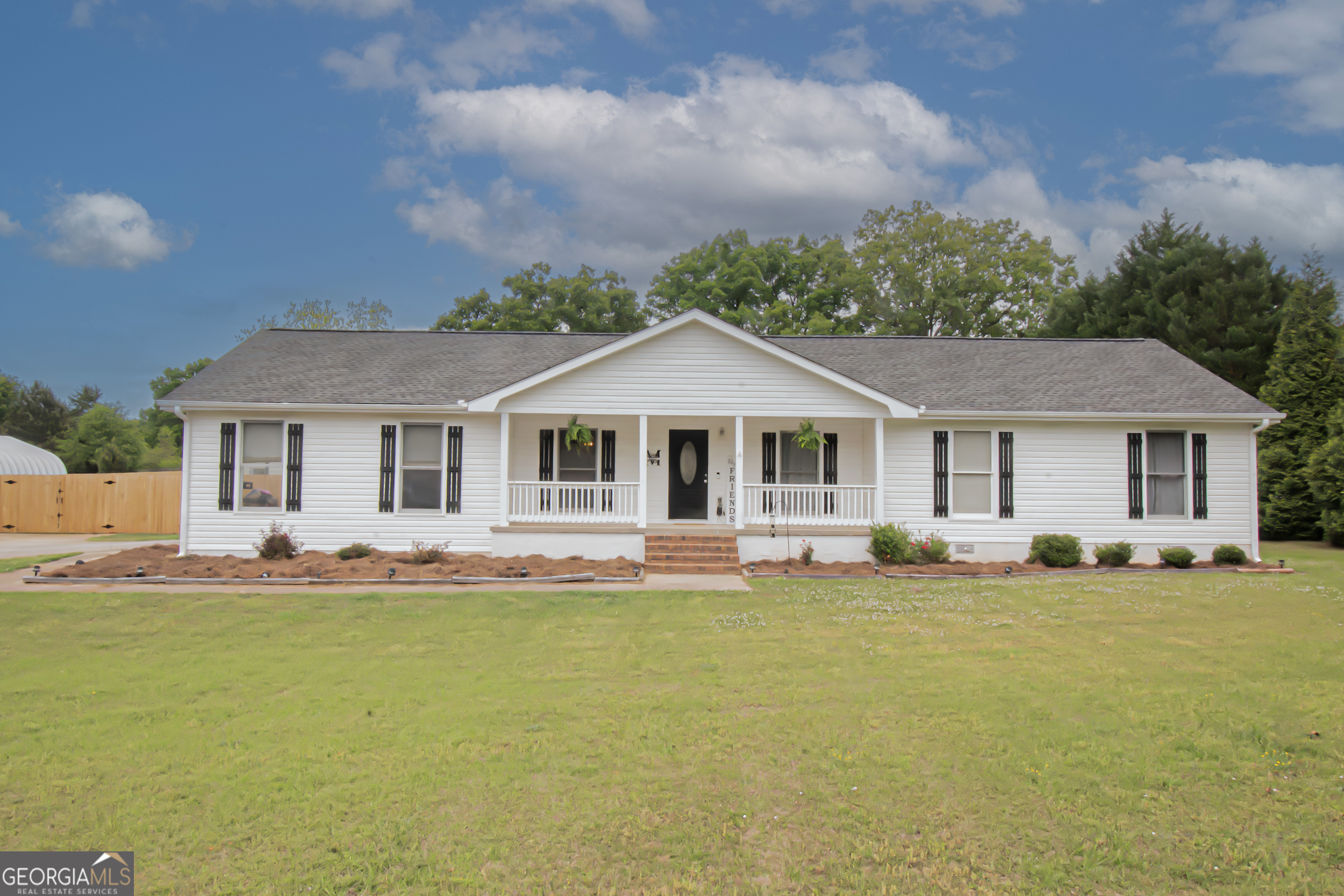 a front view of a house with a garden and deck