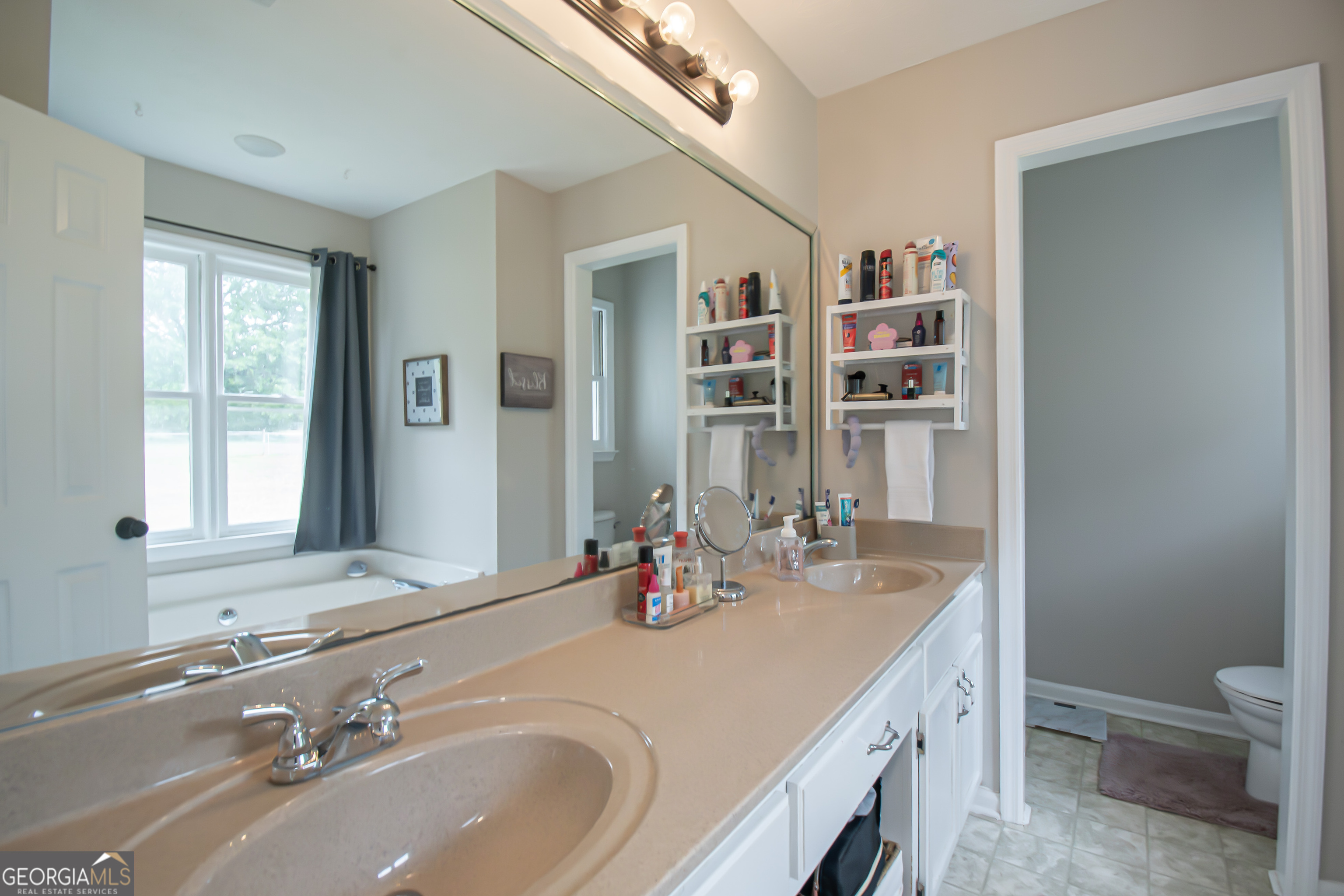 225 Graystone Drive Covington, GA 30014 - Photo 19 of 23 a bathroom with a sink a toilet and a mirror