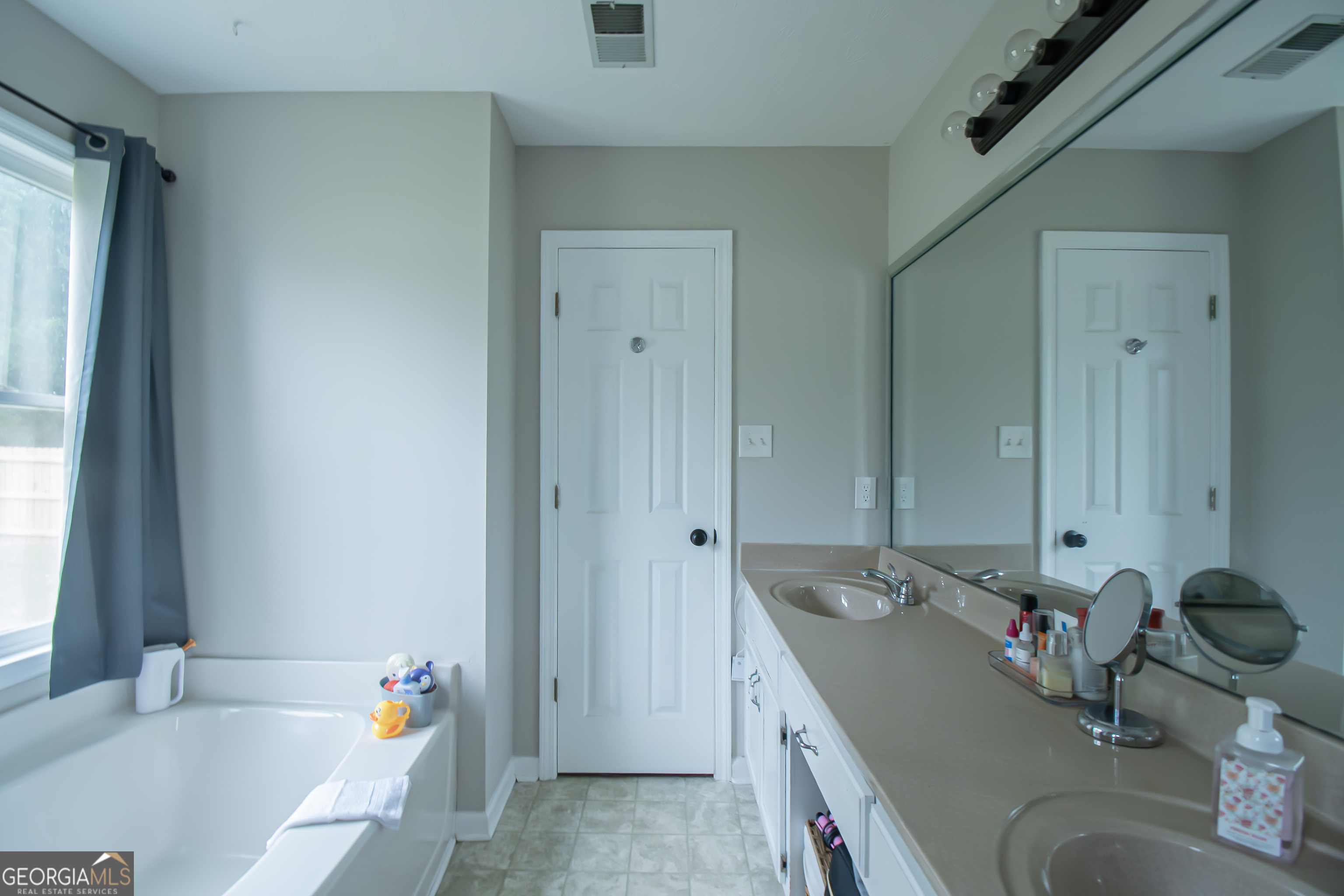 225 Graystone Drive Covington, GA 30014 - Photo 20 of 23 a bathroom with a tub sink and a mirror