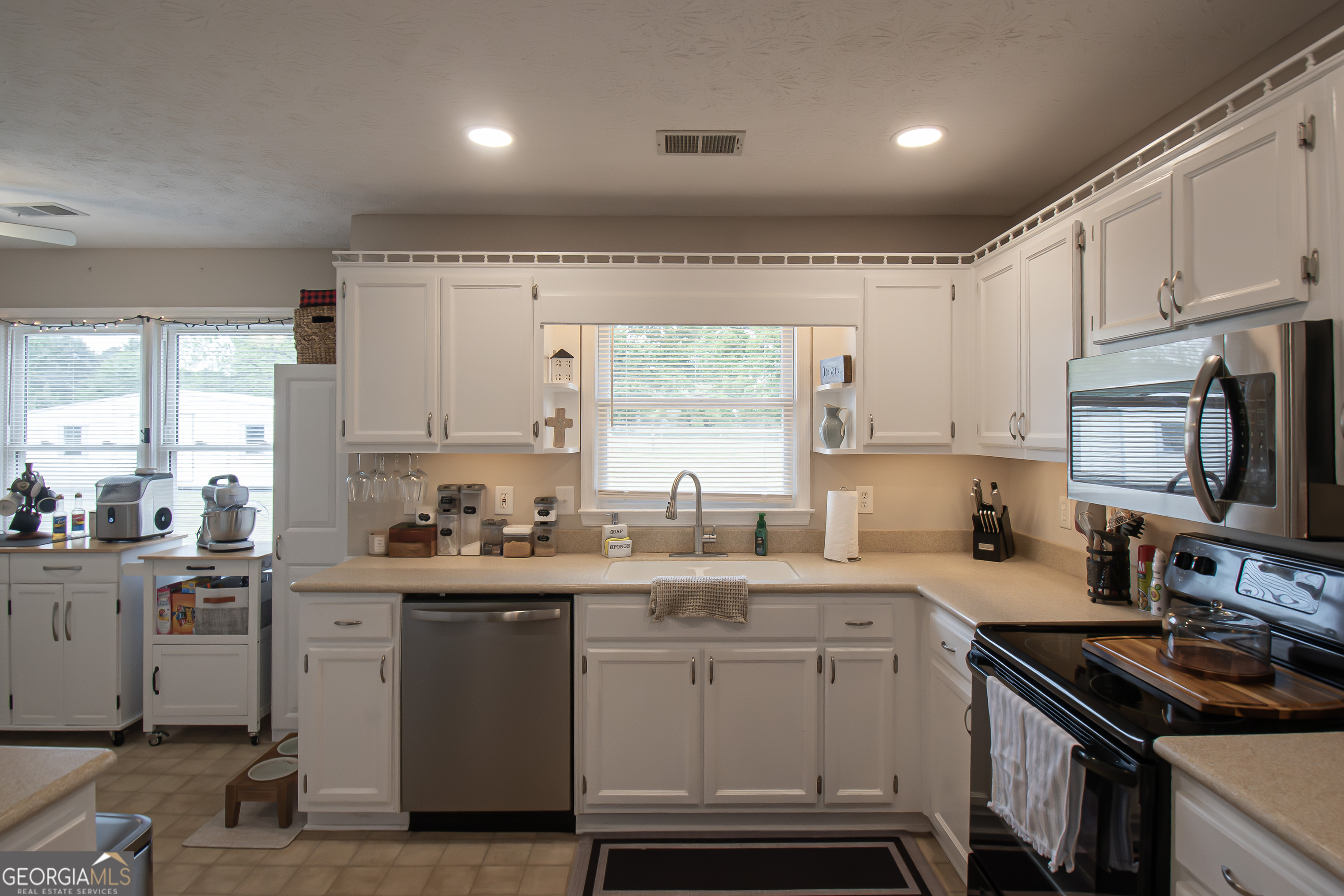 225 Graystone Drive Covington, GA 30014 - Photo 8 of 23 a kitchen with a sink stove top oven and cabinets