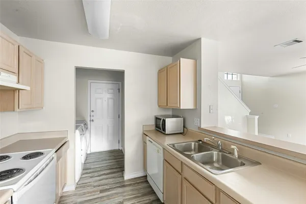 a kitchen with a sink stove top oven and cabinets