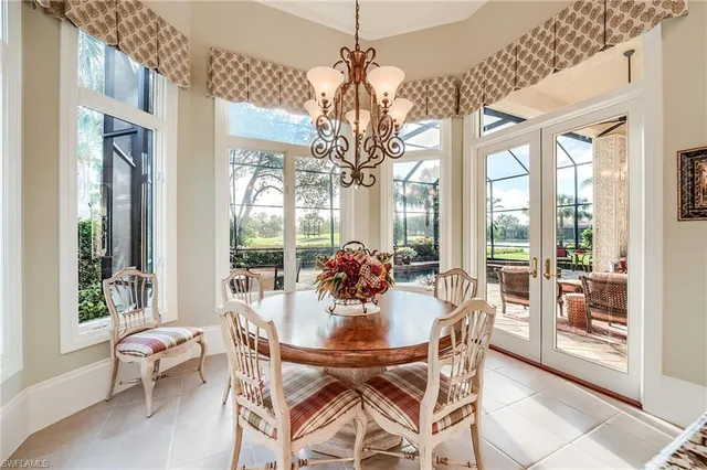 a dining room with furniture large windows and a chandelier