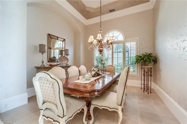 a dining room with furniture a chandelier and window