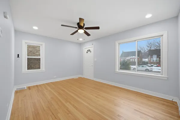 a view of an empty room with a window and a chandelier