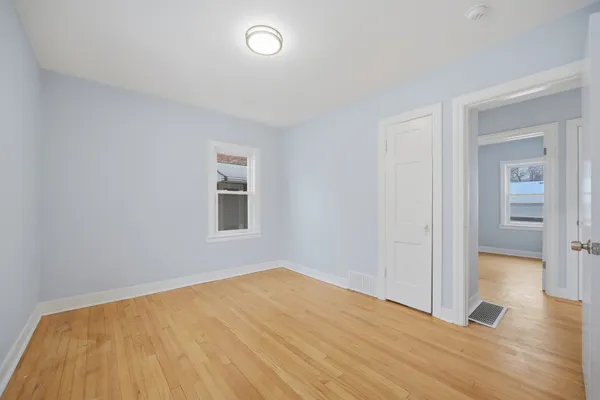 a view of empty room with wooden floor
