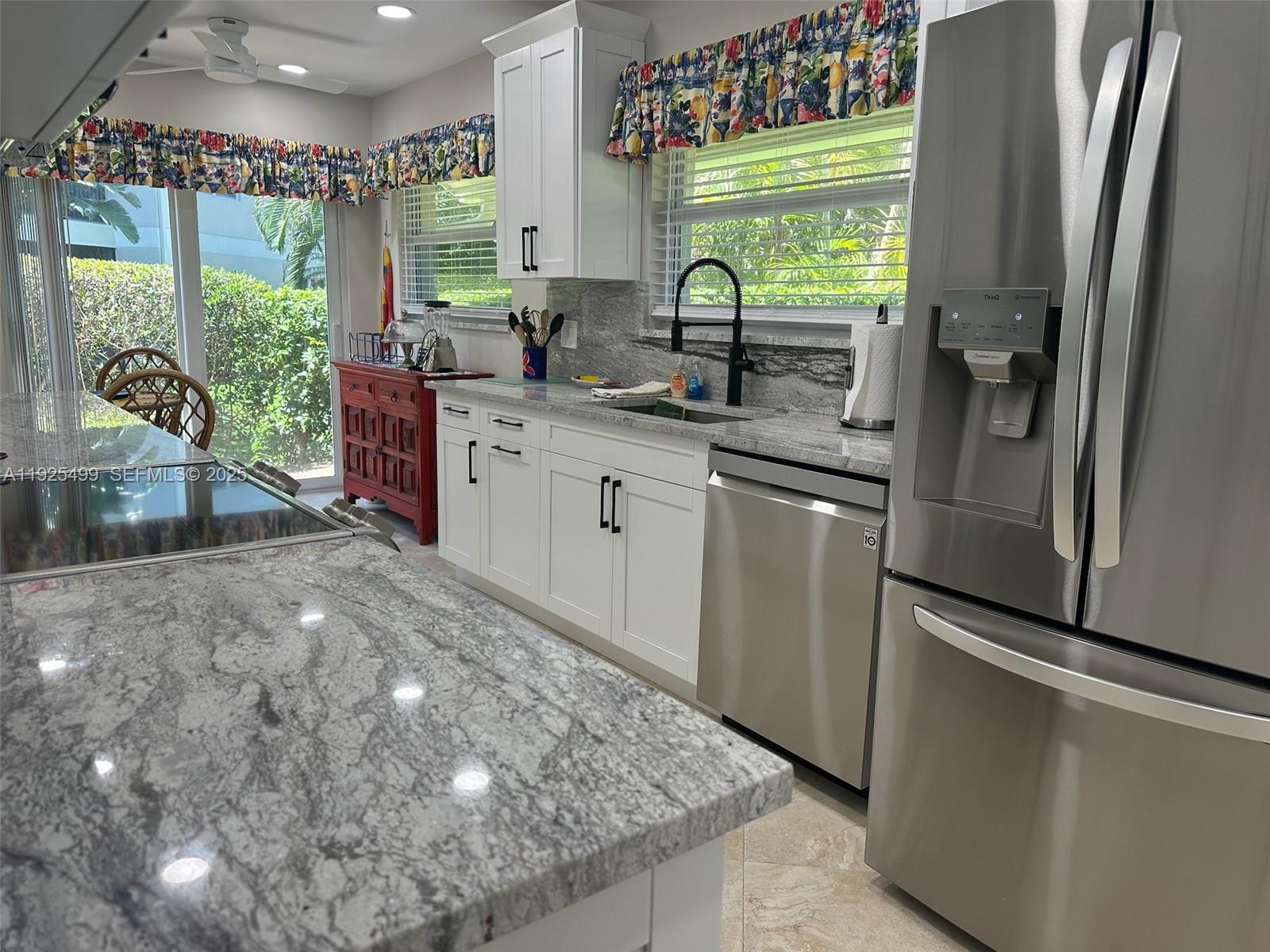 4161 South Us Highway, Unit G2 Jupiter, FL 33477 - Photo 23 of 62 a kitchen with stainless steel appliances granite countertop a refrigerator a sink dishwasher a stove a washer and dryer next to a window