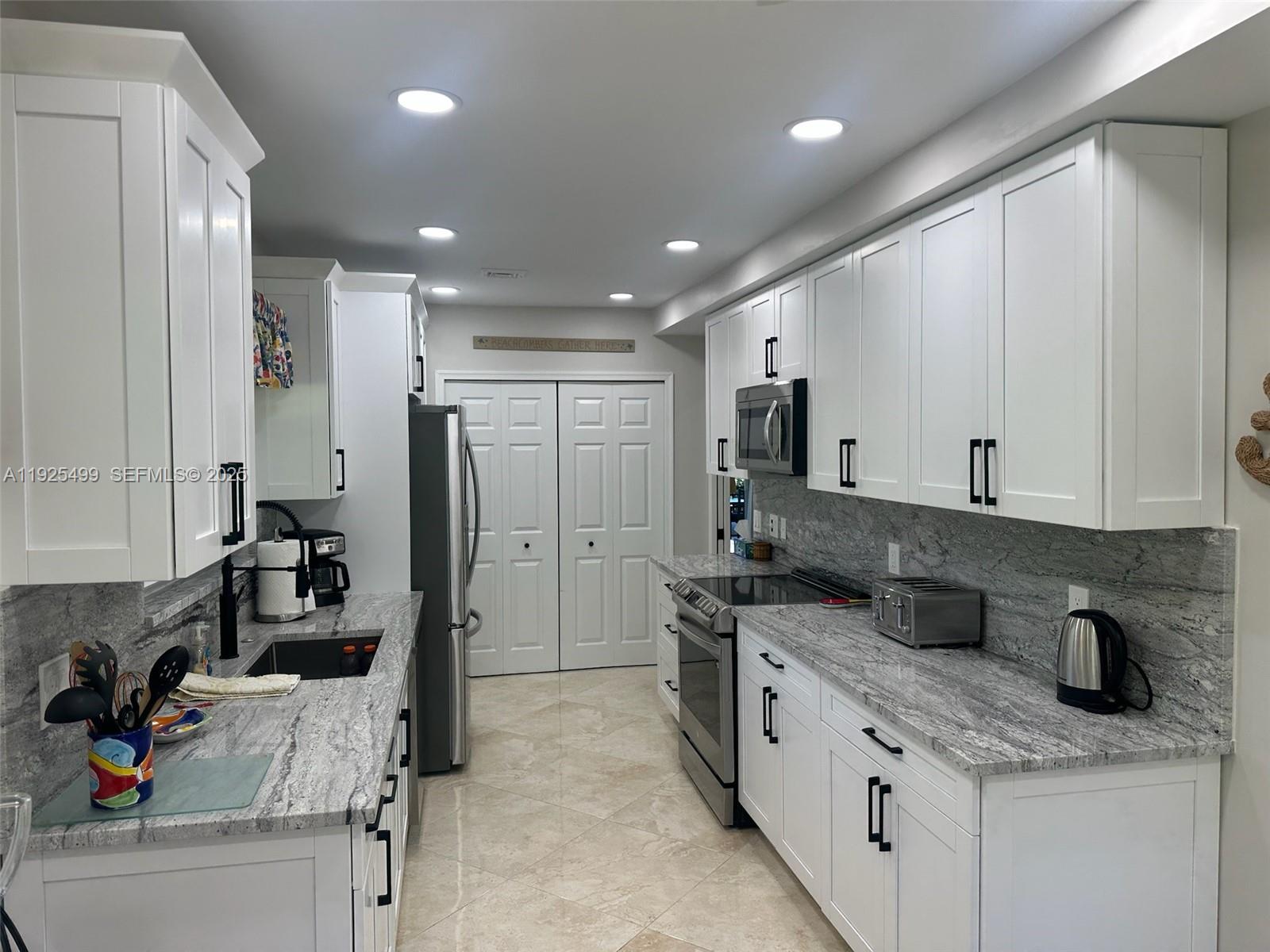 4161 South Us Highway, Unit G2 Jupiter, FL 33477 - Photo 26 of 62 a kitchen with stainless steel appliances granite countertop a sink stove and refrigerator