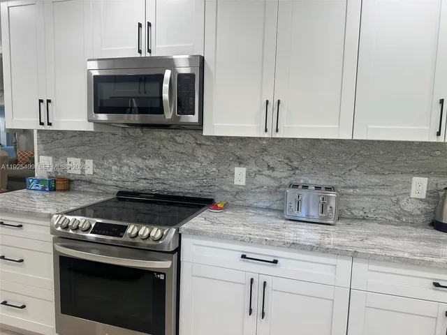 a view of a wooden table and chairs in patio of a house