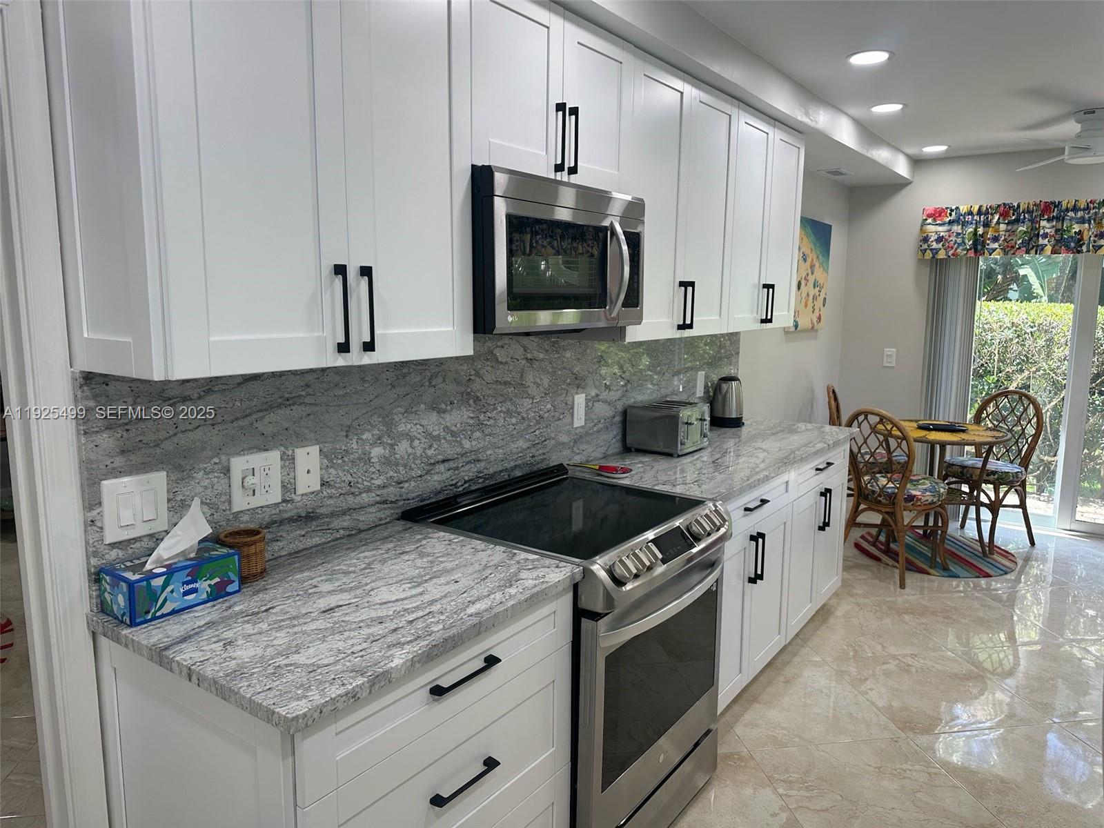 4161 South Us Highway, Unit G2 Jupiter, FL 33477 - Photo 30 of 62 a kitchen with stainless steel appliances granite countertop a stove a sink and a microwave