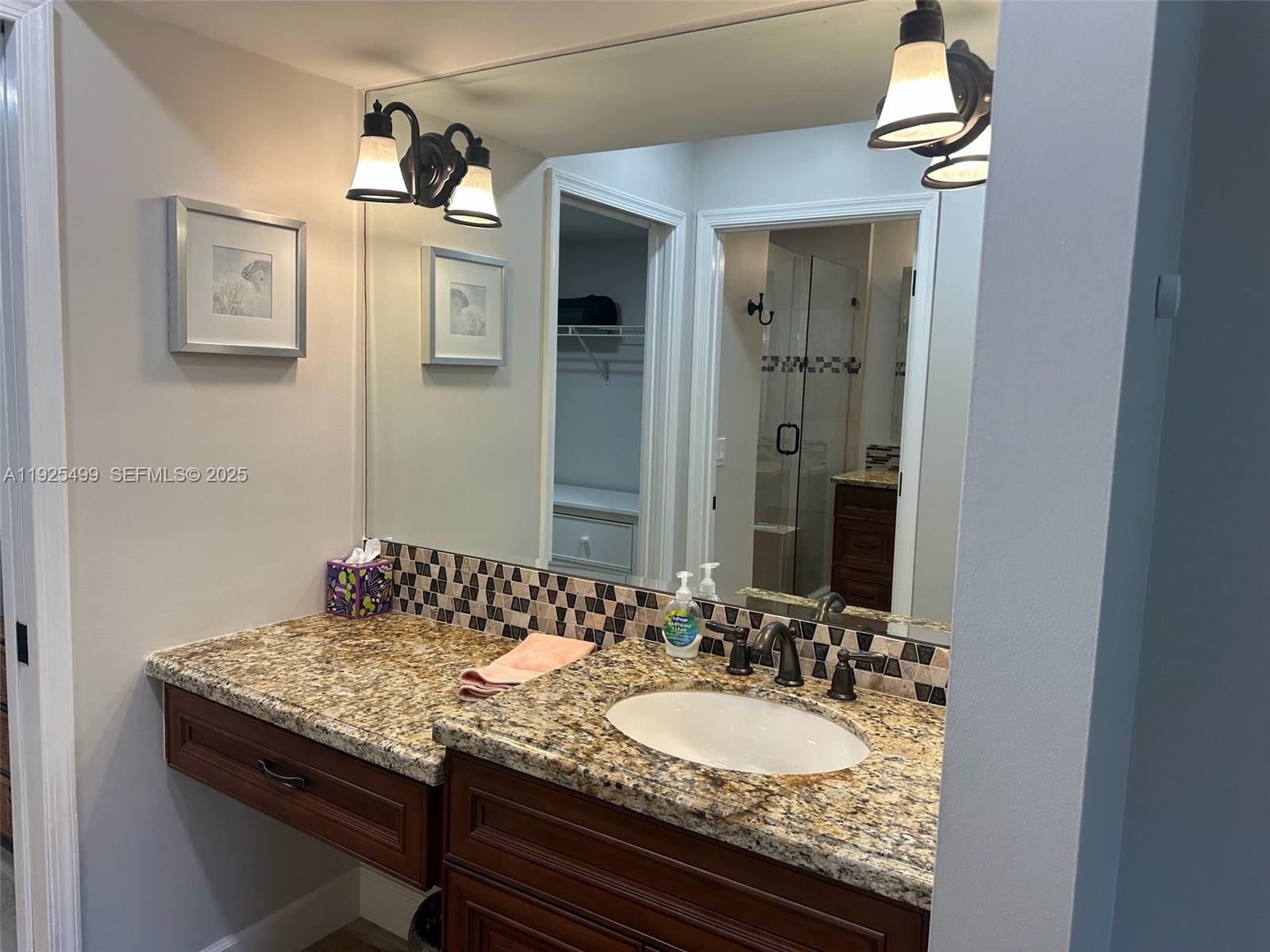 4161 South Us Highway, Unit G2 Jupiter, FL 33477 - Photo 42 of 62 a bathroom with a granite countertop sink and a mirror