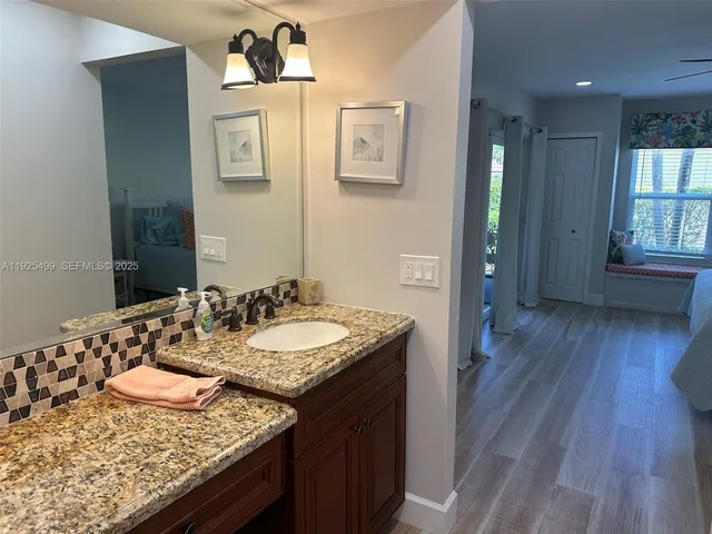 a bathroom with a granite countertop sink toilet a mirror and shower