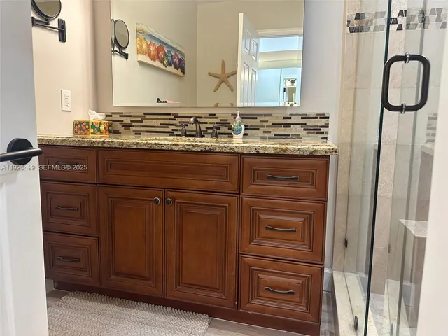 a bathroom with a granite countertop sink and a mirror