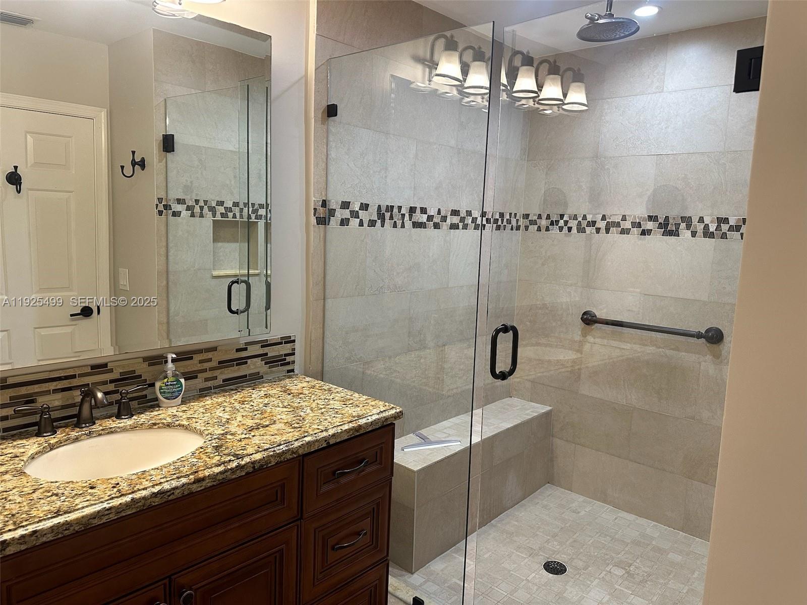 4161 South Us Highway, Unit G2 Jupiter, FL 33477 - Photo 45 of 62 a bathroom with a granite countertop sink a mirror and shower