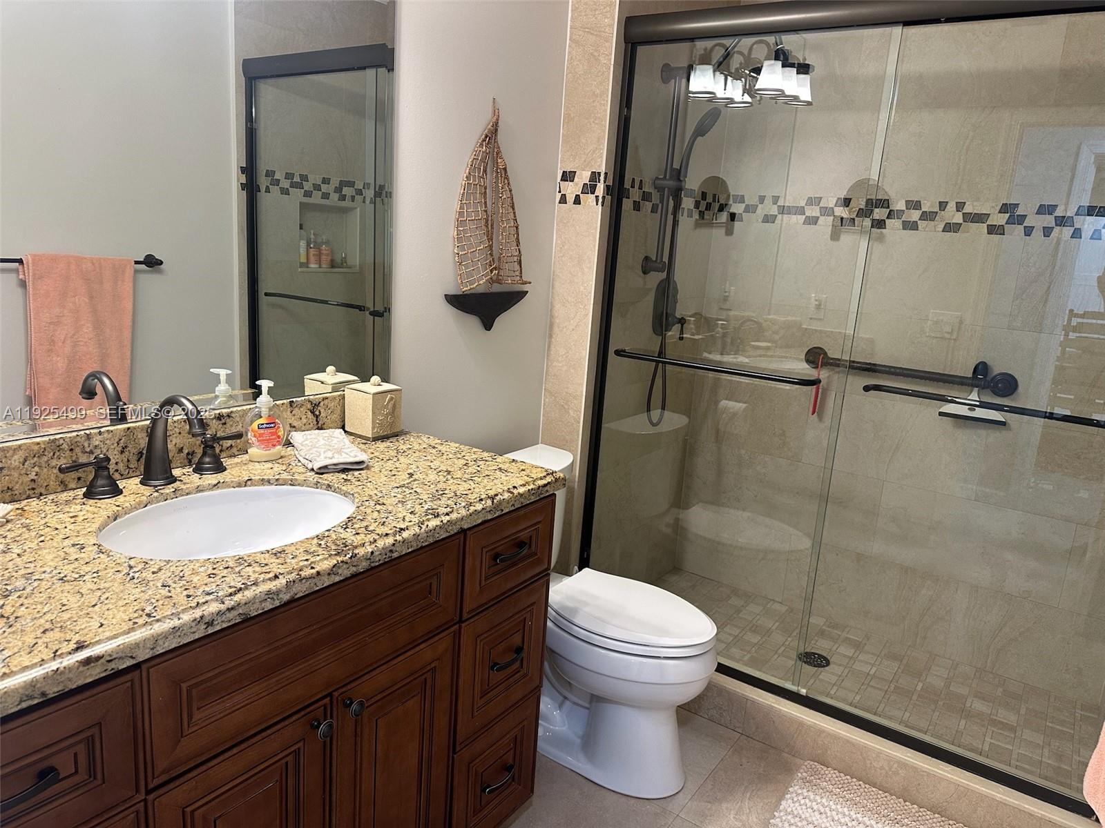 4161 South Us Highway, Unit G2 Jupiter, FL 33477 - Photo 53 of 62 a bathroom with a granite countertop sink toilet a mirror and shower