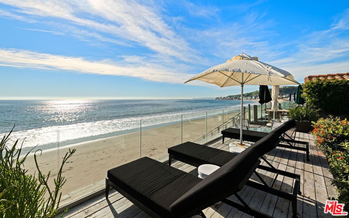 a view of a balcony with furniture and umbrella