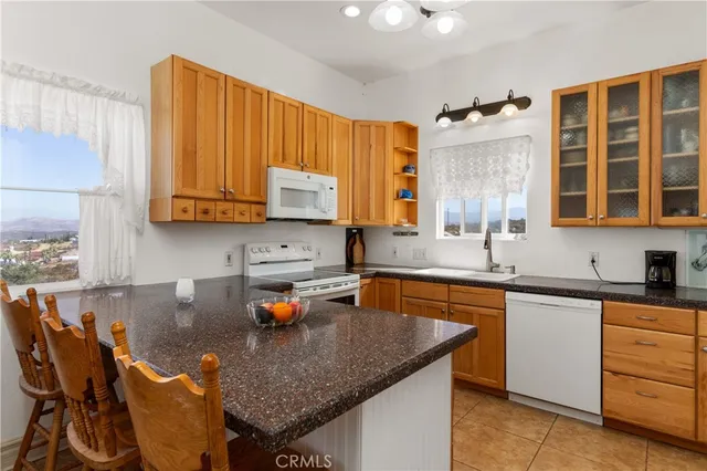 a kitchen with granite countertop a sink stove and cabinets