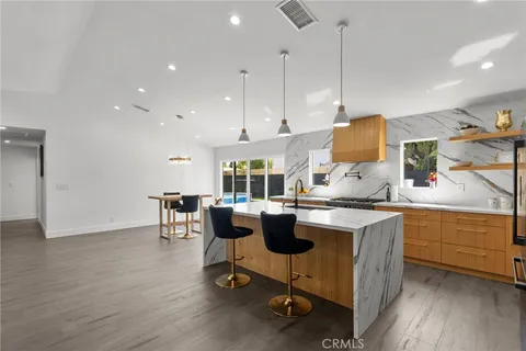 a kitchen with a table chairs stove and cabinets