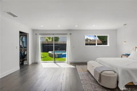 a bedroom with a bed and a wooden floor