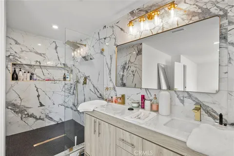 a bathroom with a sink vanity mirror and shower