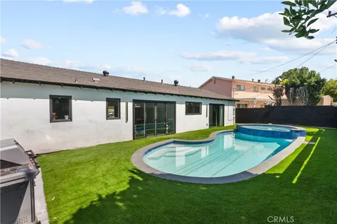 a view of a house with swimming pool and a yard
