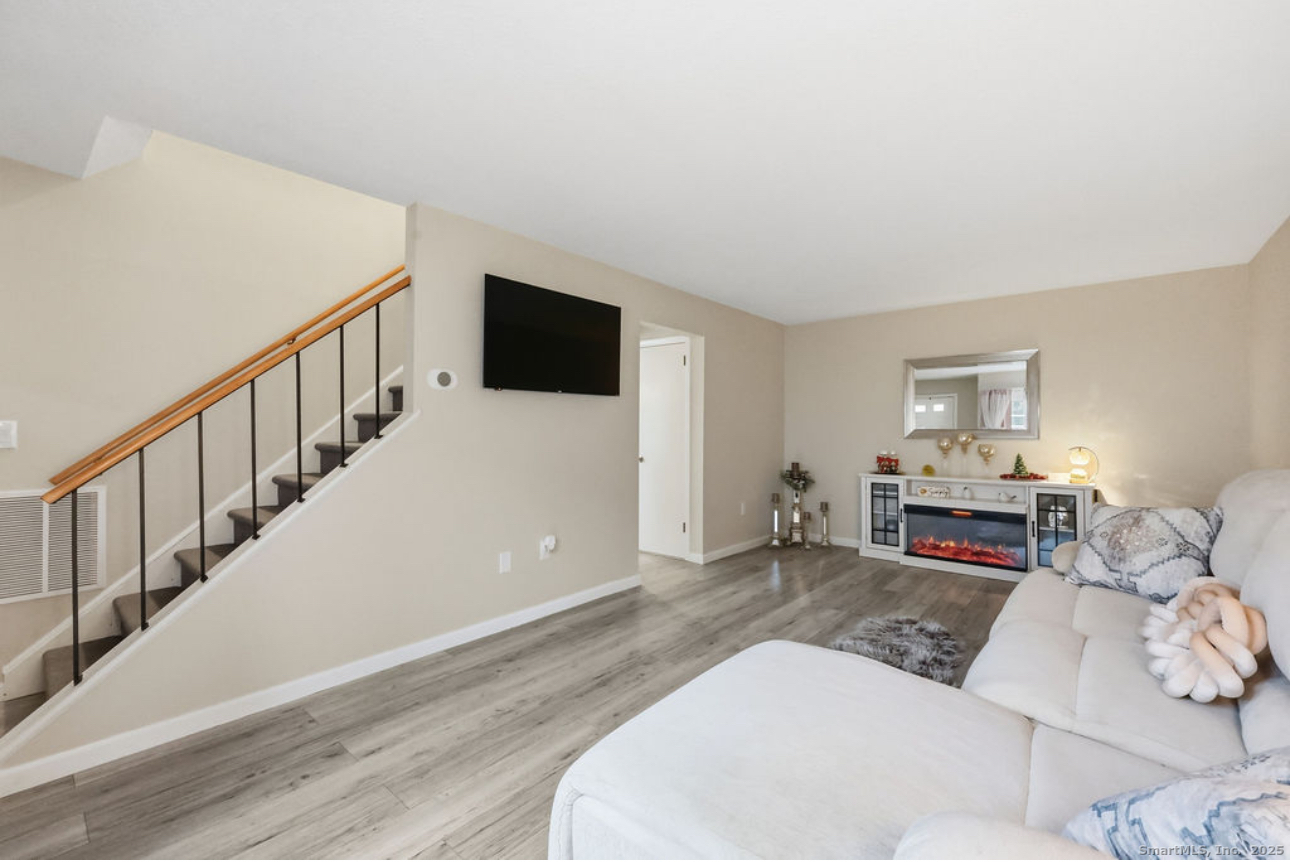 39 Cottonwood Road, Unit 39 Newington, CT 06111 - Photo 3 of 21 a living room with furniture a fireplace and a flat screen tv