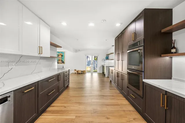 a large kitchen with stainless steel appliances and a large counter top