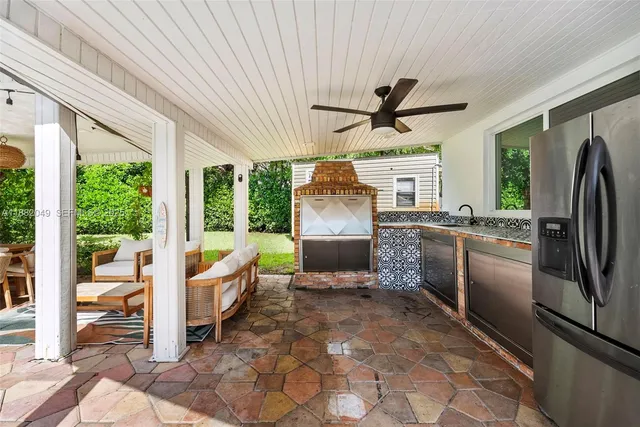 a kitchen with stainless steel appliances granite countertop a refrigerator a sink a stove and white cabinets with wooden floor