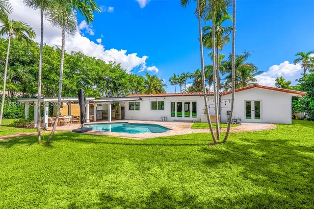 a view of a house with a swimming pool and a yard