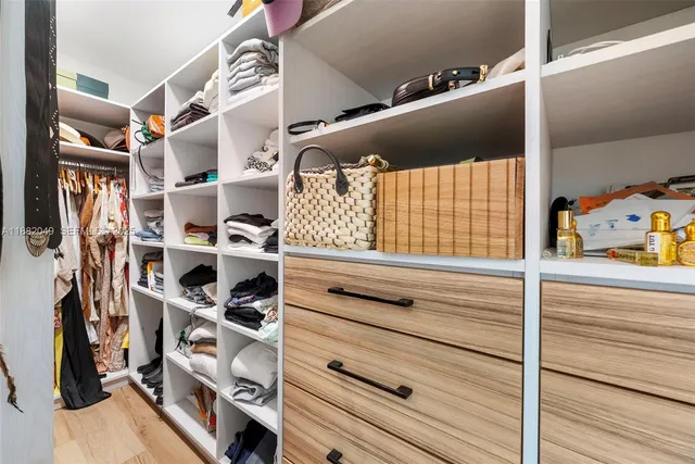 a view of walk in closet with clothes and shoes
